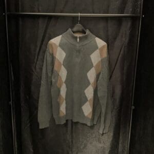 A sweater hanging on a rack in a room.