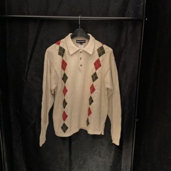 A white shirt with red and green argyle pattern on it.