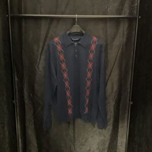 A black and red shirt hanging on a rack.