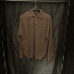 A brown shirt hanging on a metal rack.