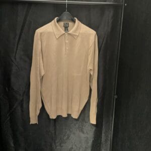 A tan shirt hanging on the wall