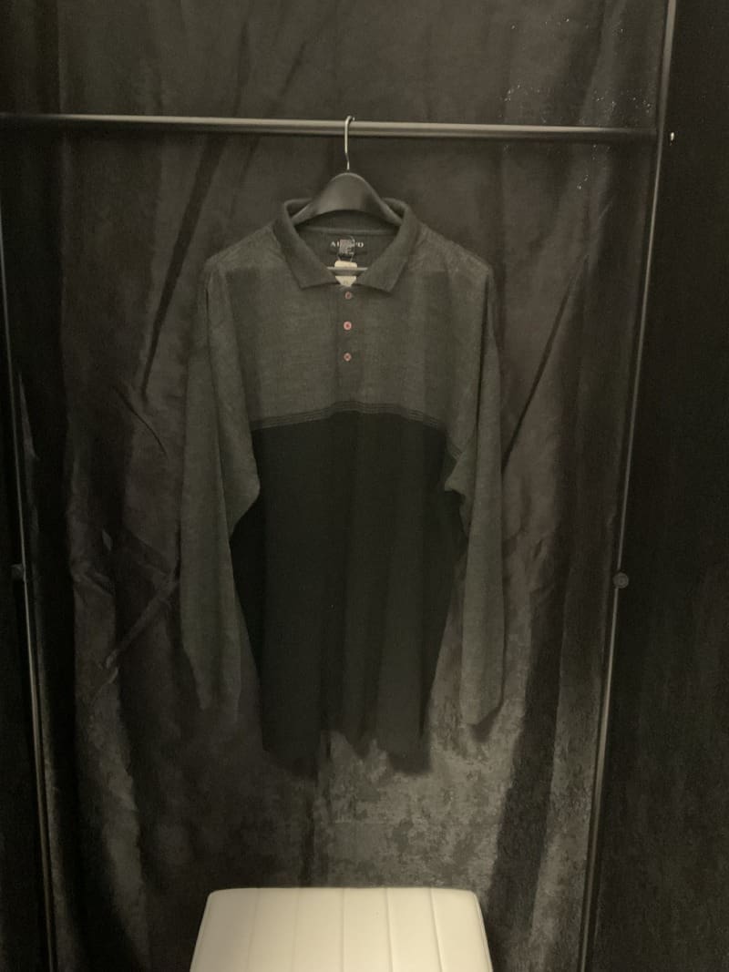 A black shirt hanging on the wall in a room.