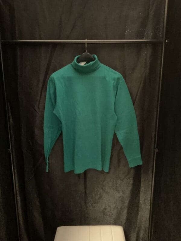 A green shirt hanging on a rack