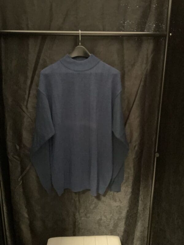 A blue shirt hanging on the wall