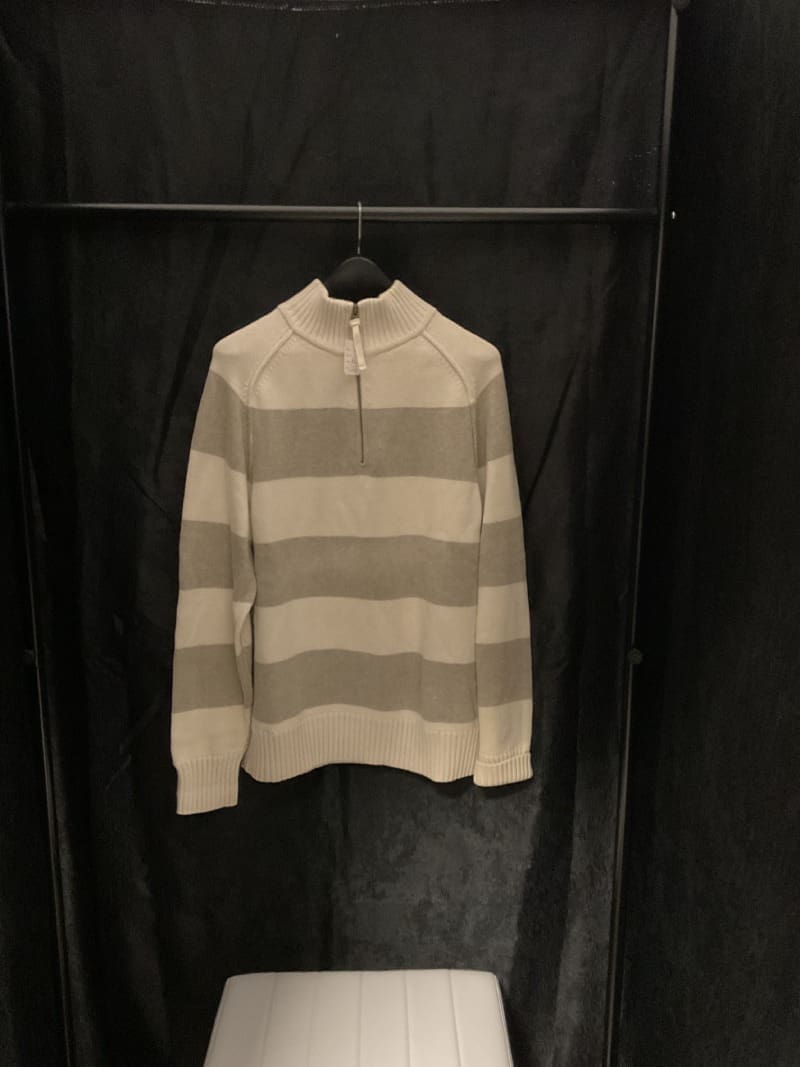 A striped sweater hanging on a rack.