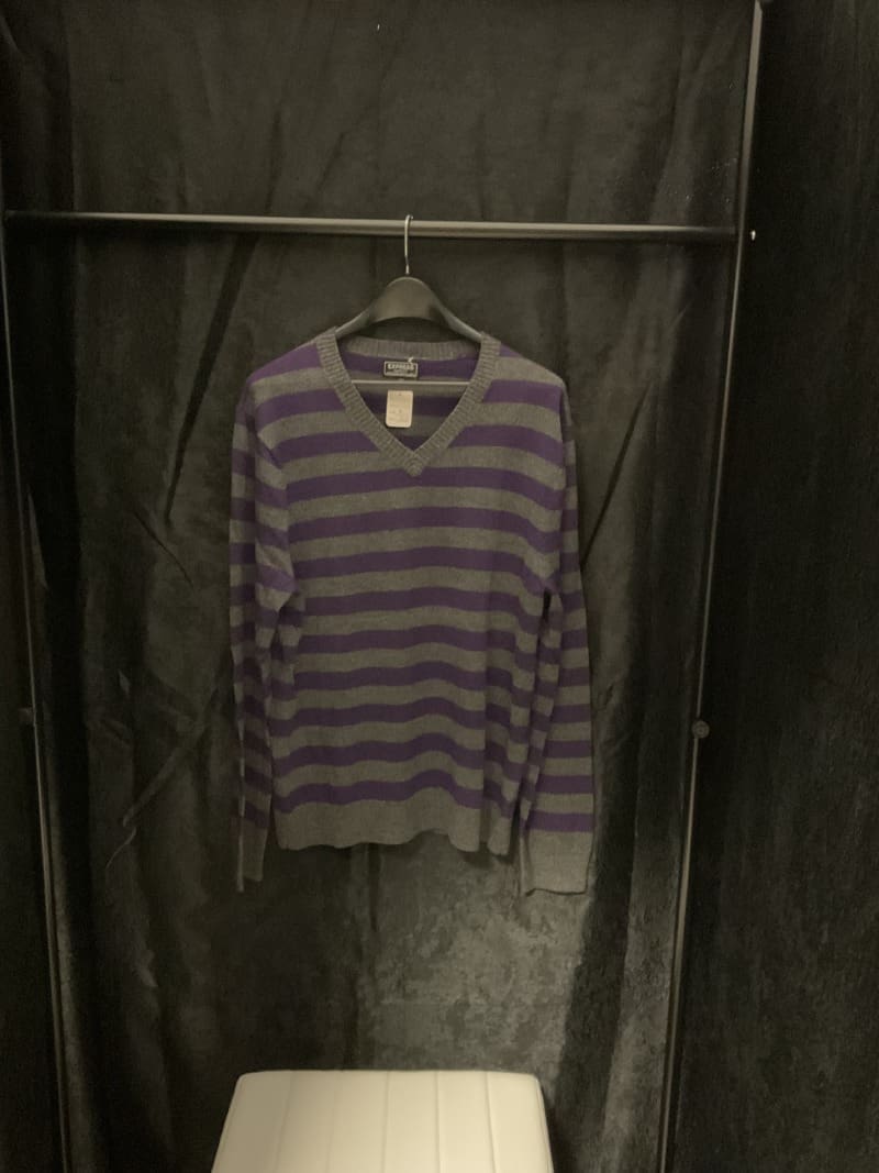 A purple and gray striped sweater hanging on a rack.