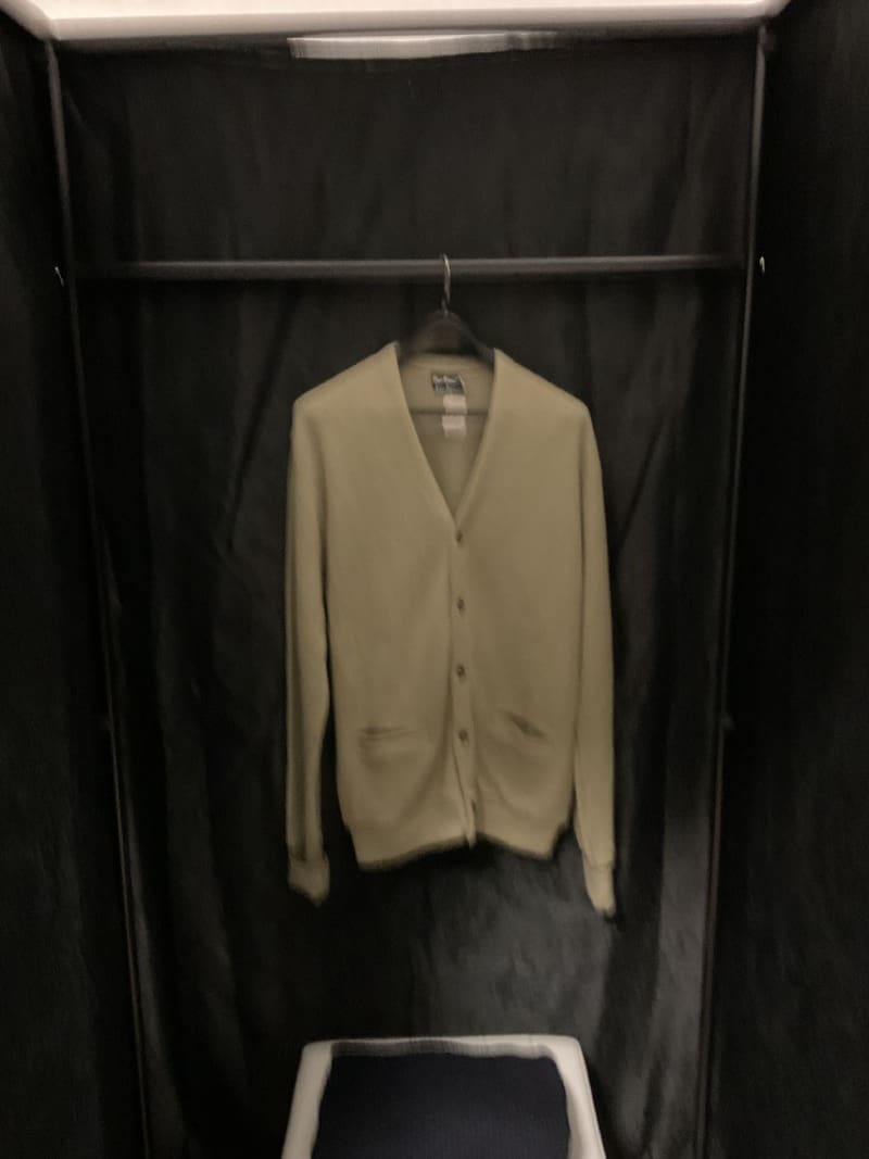 A coat hanging on a rack in a room.