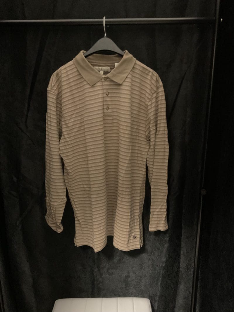 A white shirt with black stripes hanging on the wall.