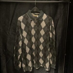 A black and white argyle shirt hanging on a rack.