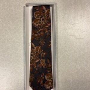 A brown tie with some flowers on it