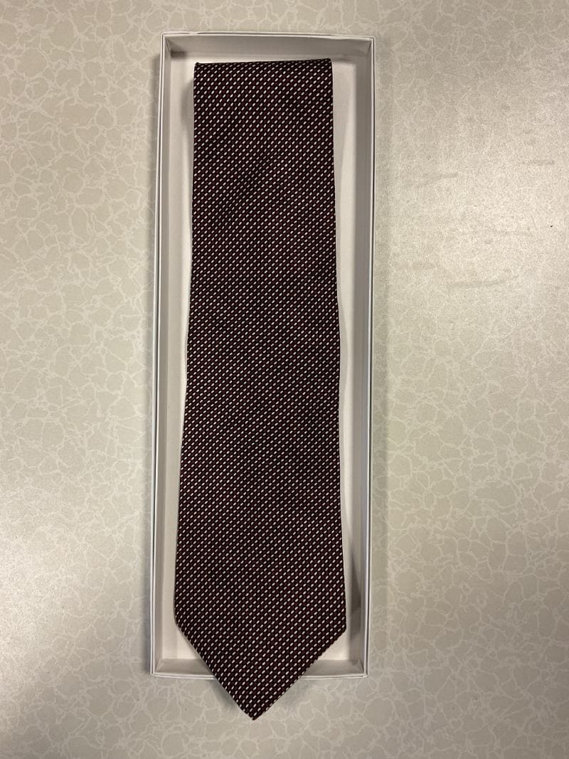 A brown tie in a box on top of a table.