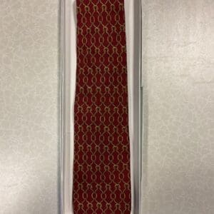 A red tie with gold thread in a box.