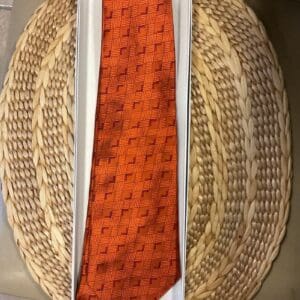 A basket with two ties on top of it.