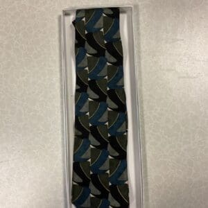 A tie that is in its box on top of the floor.