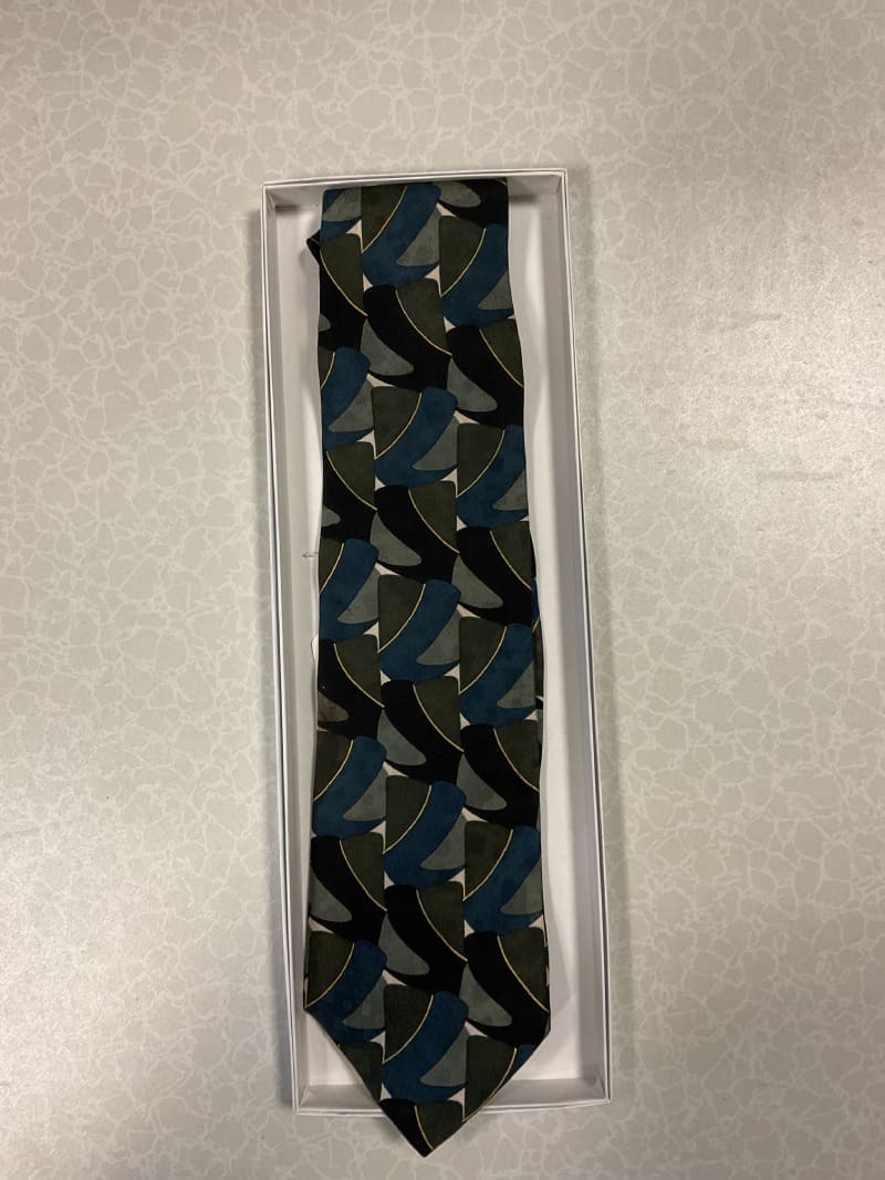 A tie that is in its box on top of the floor.