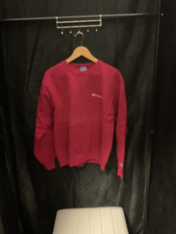 A red sweater hanging on the wall