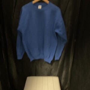 A blue sweater hanging on the wall