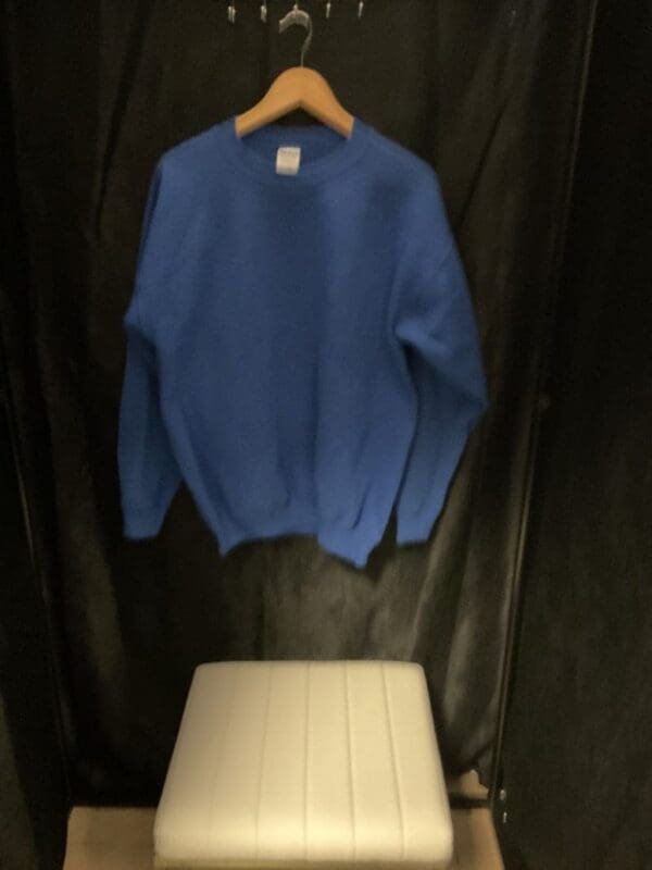 A blue sweater hanging on the wall