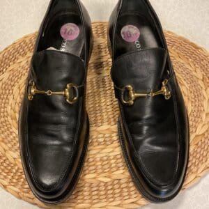 A pair of black shoes sitting on top of a wicker mat.