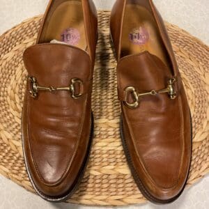 A pair of brown shoes sitting on top of a wicker mat.