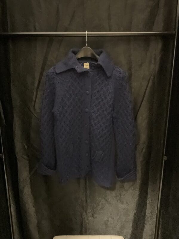 A dark blue sweater hanging on the wall.