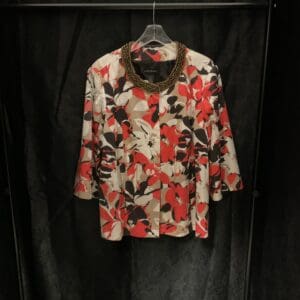 A black and red floral shirt hanging on a wall.