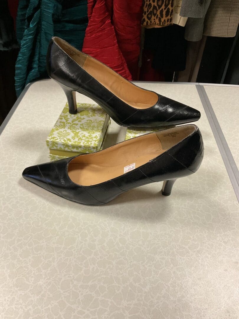 A pair of black shoes sitting on top of a table.