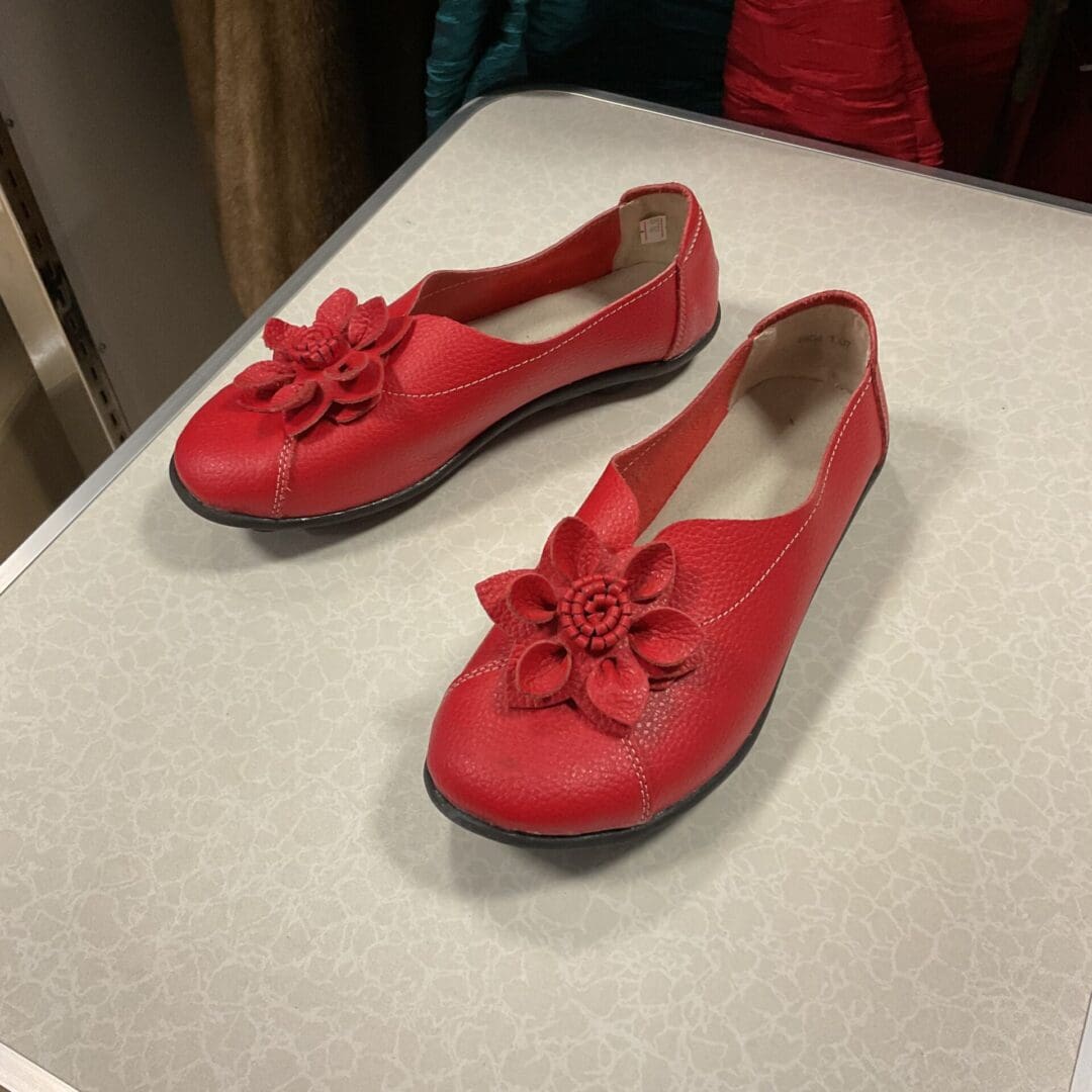 A pair of red shoes sitting on top of a table.