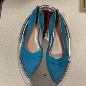 A pair of blue shoes sitting on top of a mirror.