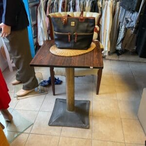 A table with a bag on it in the middle of a room.