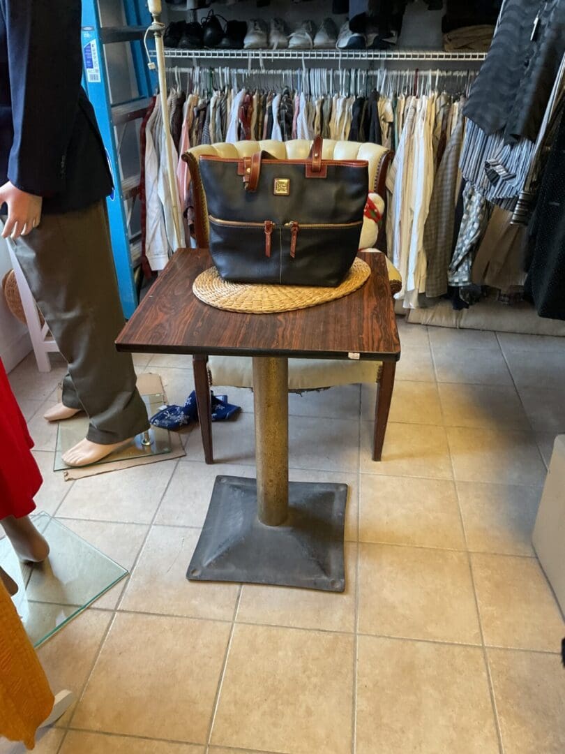 A table with a bag on it in the middle of a room.