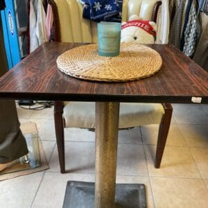 A table with a cup on it and a chair in the background.