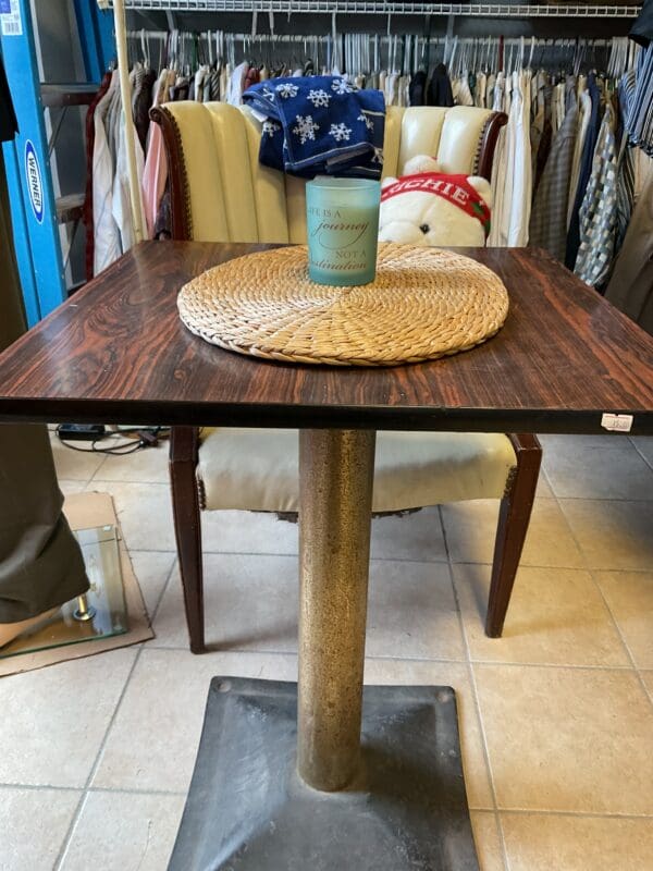 A table with a cup on it and a chair in the background.