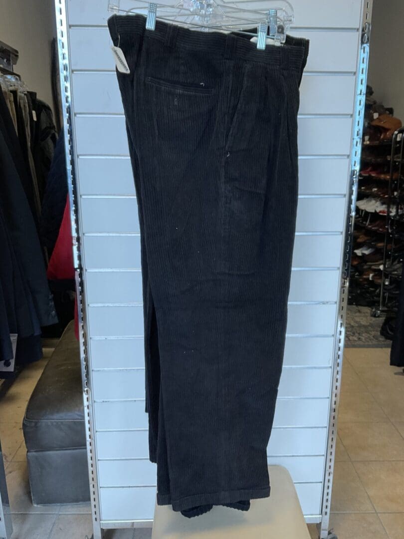 A black color pant hanging on the wall